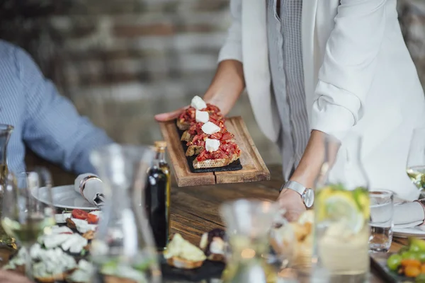 Vrouw diner Party Host eten serveren aan haar vrienden — Stockfoto
