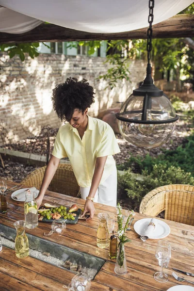 Vrouw versieren tabel voor diner in de buitenlucht partij — Stockfoto