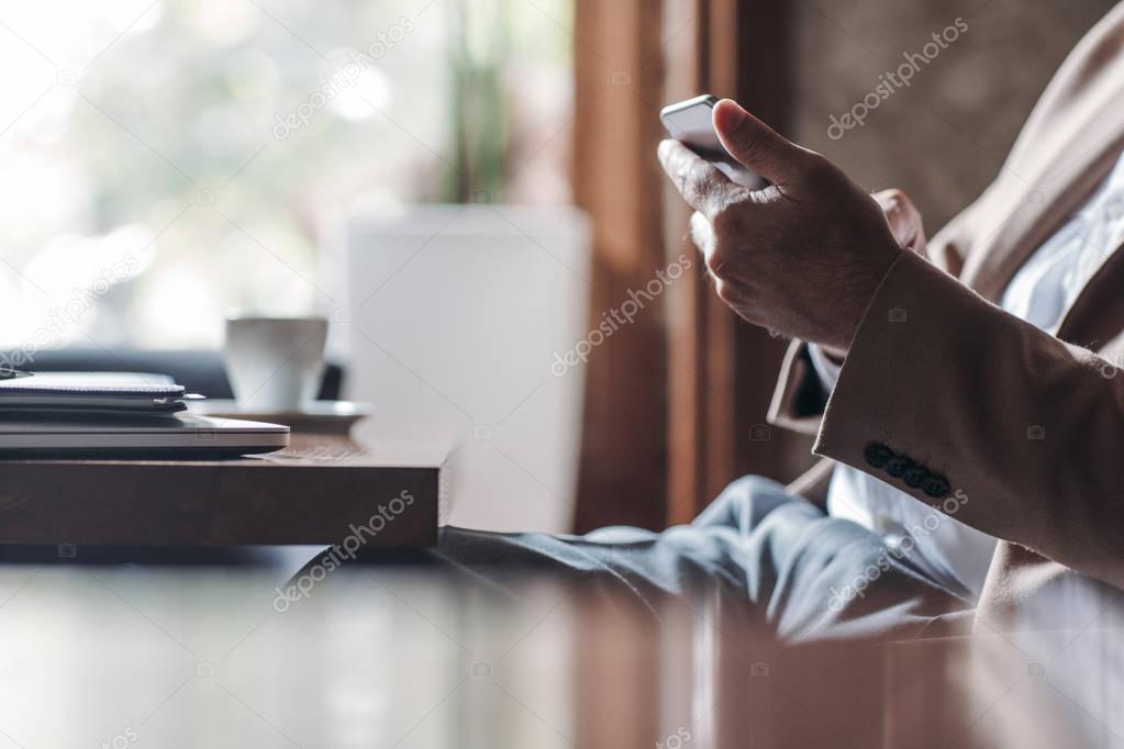 Businessman Typing on Cell Phone