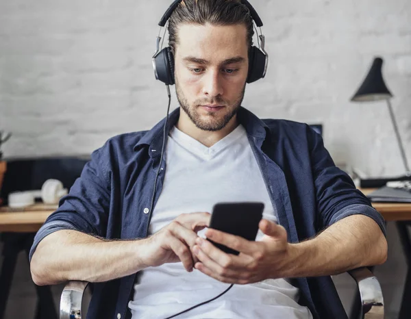 Człowiek słuchający muzyki na słuchawkach — Zdjęcie stockowe