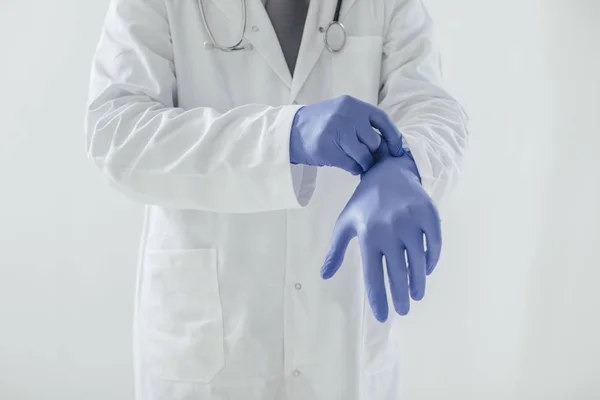 Doctor poniéndose guantes — Foto de Stock