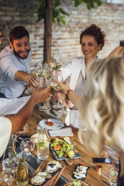 Vrienden juichen met witte wijn — Stockfoto