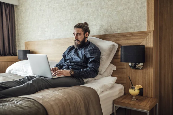 Biznesmen pisania na laptopa o Hotel — Zdjęcie stockowe