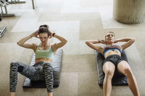 两个漂亮的白种女人在健身房锻炼 — 图库照片