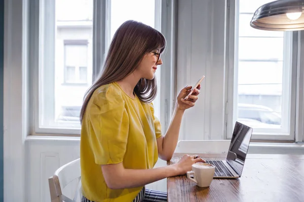 Donna utilizzando smartphone in caffetteria — Foto Stock