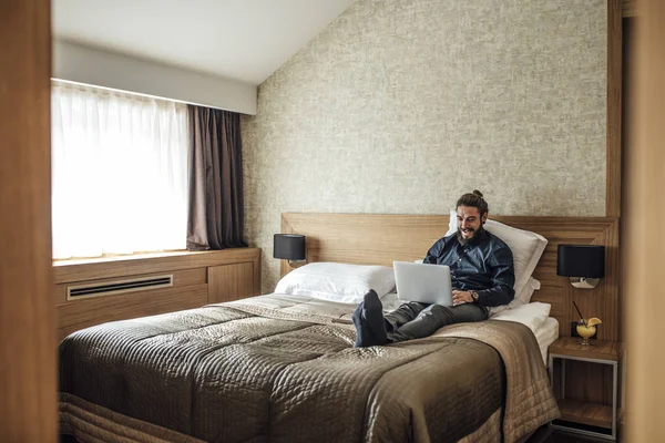 Empresário digitando no laptop no hotel — Fotografia de Stock