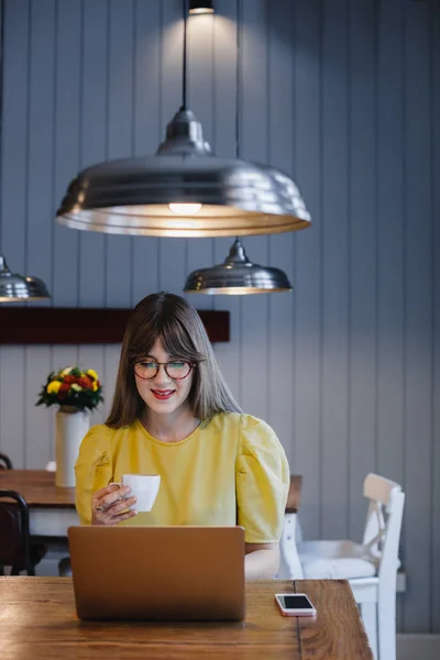 Kahve dükkanında dizüstü bilgisayar kullanan kadın — Stok fotoğraf