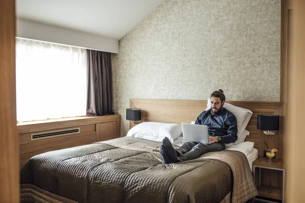 Biznesmen pisania na laptopa o Hotel — Zdjęcie stockowe