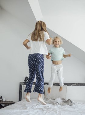 Çocuklar yatakta zıplıyor