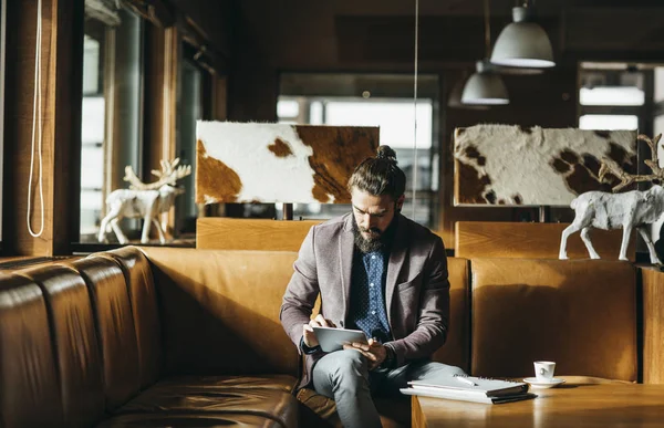 Businessman Sitting at Mountain Hotel and Using Tablet