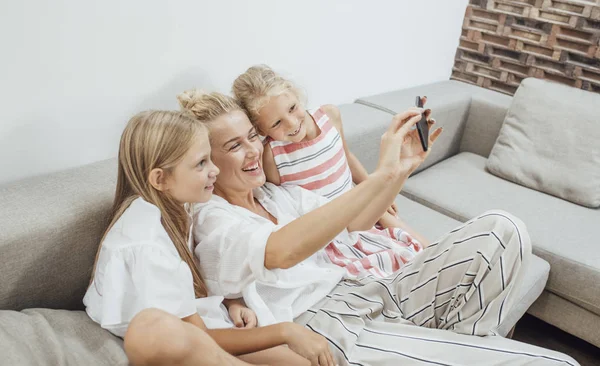 Moeder en kinderen met behulp van de mobiele telefooncamera — Stockfoto