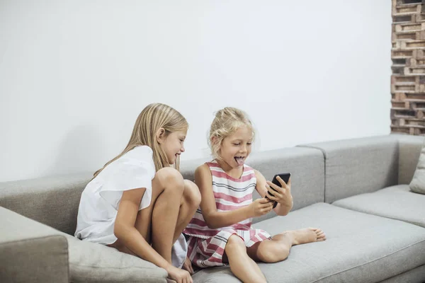 Zusters spelen met Smartphone — Stockfoto