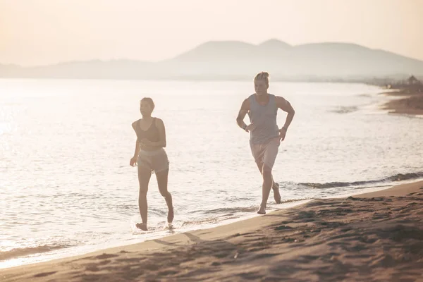 Mann und Frau laufen am Meer entlang — Stockfoto