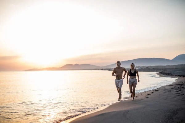 Sportsman et Sportswoman Courir sur la plage — Photo