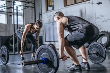 Erkek ve kadın spor salonunda ağırlık kaldırma