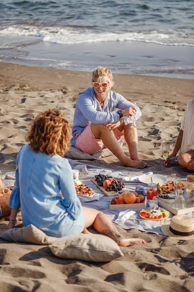 Amigos fazendo piquenique na praia — Fotografia de Stock