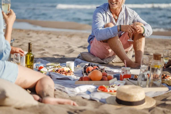 Amici che si godono un picnic sulla spiaggia — Foto Stock