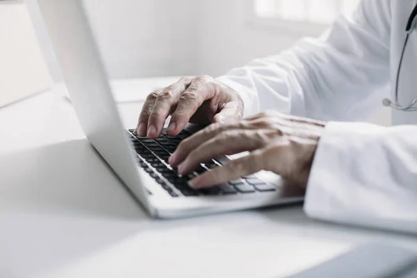 Um médico digitando no laptop — Fotografia de Stock
