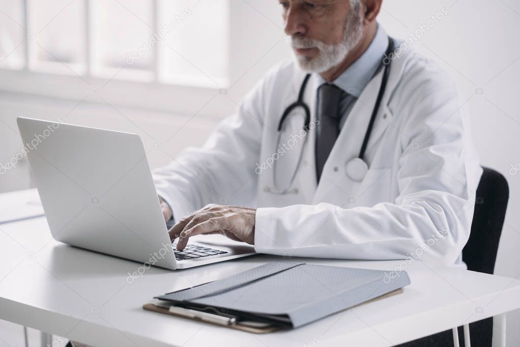 A Doctor Typing on Laptop