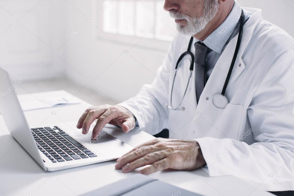 A Doctor Typing on Laptop