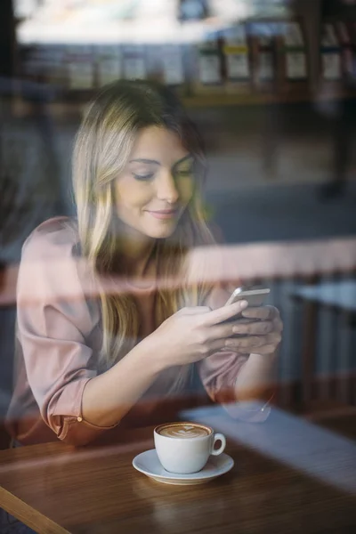 Όμορφη γυναίκα, πληκτρολογώντας στο κινητό στο καφενείο — Φωτογραφία Αρχείου