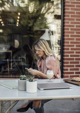 Cep telefonu kullanan genç bir kadın.