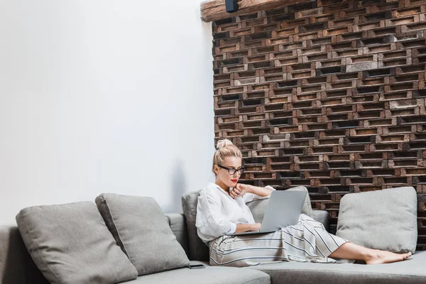 Hübsche Frau liest auf Laptop — Stockfoto