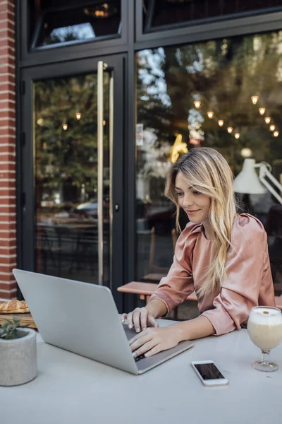 En kvinna skriver på Laptop på kafé — Stockfoto