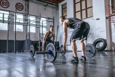 Erkek ve kadın spor salonunda ağırlık kaldırma