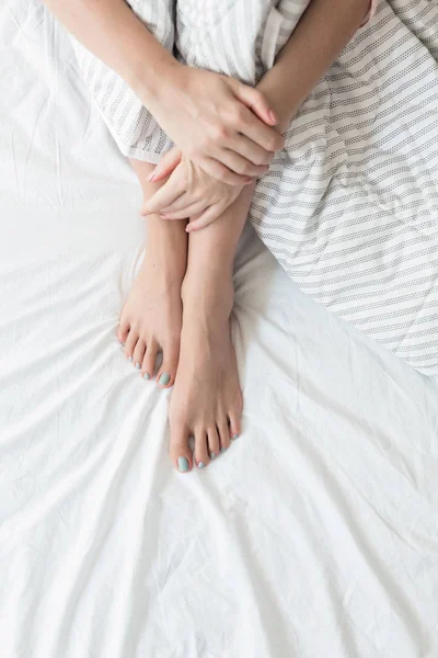 Женщина сидит на своей кровати — стоковое фото