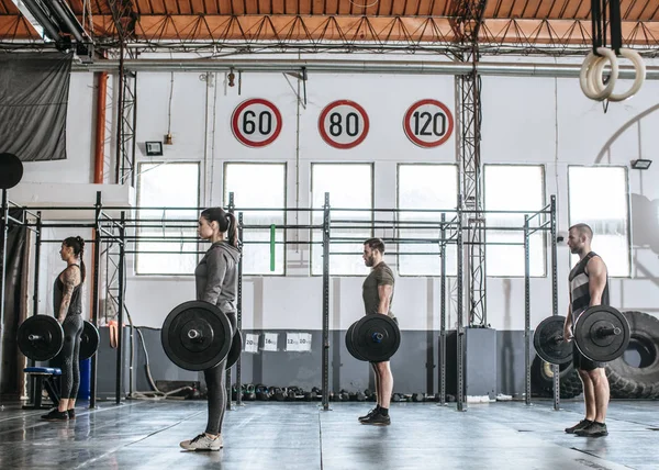 Gente haciendo ejercicios en el gimnasio — Foto de Stock