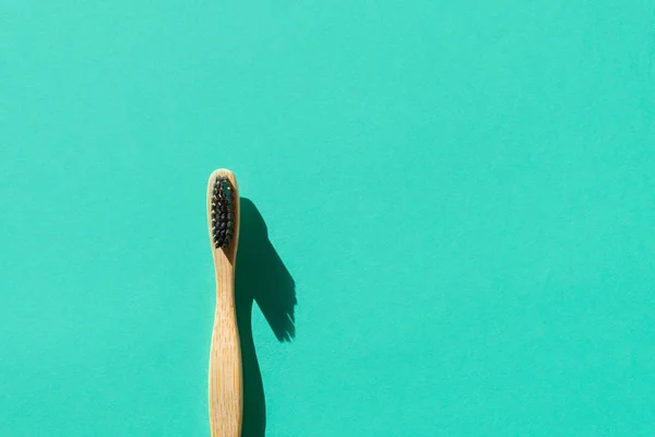 Çevre dostu bambu diş fırçası yeşil kağıt arka planda biyolojik olarak çözünebilir malzemelerden yapıldı — Stok fotoğraf