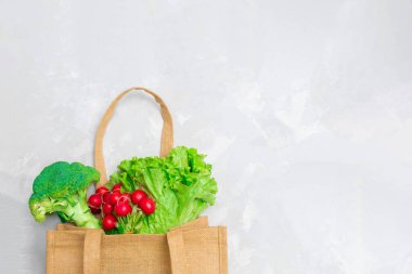 Gri tarafsız arka planda sebzeli tekrar kullanılabilir tekstil alışveriş torbası