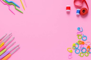 Yumuşak pembe arkaplanda, kopyalama alanı olan renkli tığ işi ve örgü aksesuarları