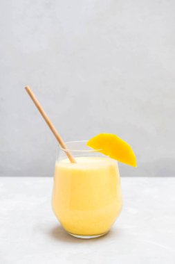 Tarafsız gri arka planda cam bir fincanda Mango Lassi