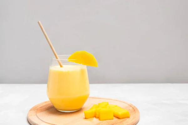 Indický nápoj na bázi jogurtu Mango Lassi na šedém neutrálním pozadí — Stock fotografie