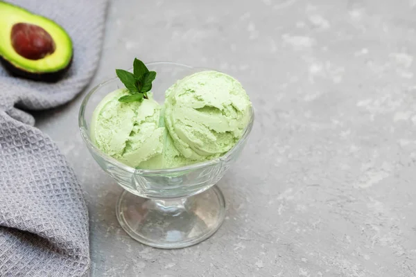 Ice cream with avocado, frozen banana, mint leaves on grey concrete background with copy space