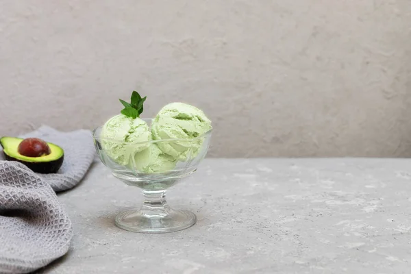 Scoops of green avocado ice cream on neutral background. Image with copy space