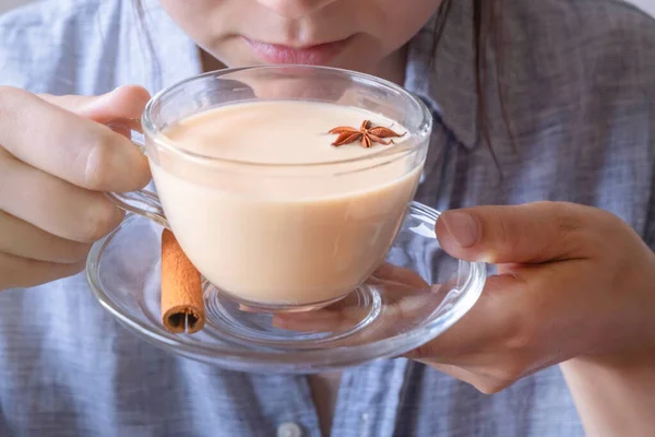Genç beyaz kadın bir fincan Masala Chai çayına eşlik ediyor.