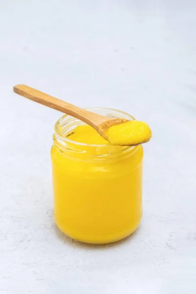 Pure desi ghee in a jar with wooden spoon — Stock Photo, Image