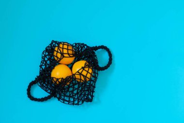 Parlak mavi arka planda portakallı tekstil kumaş alışveriş torbası. Kopyalama alanı olan resim, en üst görünüm