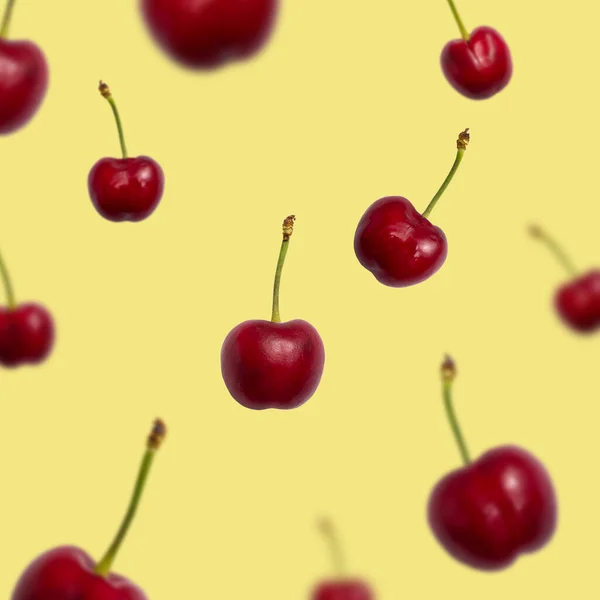 Bagas de cereja maduras frescas textura de tamanhos diferentes em voo — Fotografia de Stock