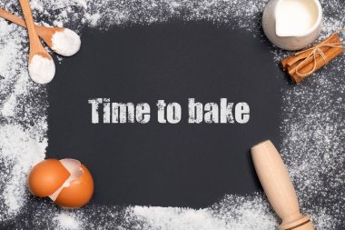 Pişirme malzemeleriyle siyah arkaplanda yazı yazma zamanı. Ev yapımı konsept, kek ya da kurabiye malzemeleri