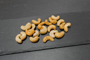 Siyah arka planda tuzlu kaju fıstığı. Sağlıklı çerez