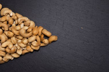 Siyah arka planda tuzlu kaju fıstığı. Sağlıklı çerez