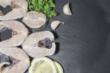 Arka planda otlar ve limonlu lezzetli mersin balığı bifteği.