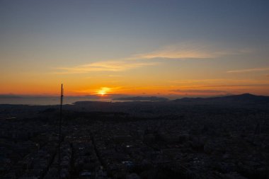 Atina 'da gün batımı bulutlu bir gökyüzünde, Atina' daki Lycabettus tepesinden kent manzaralı