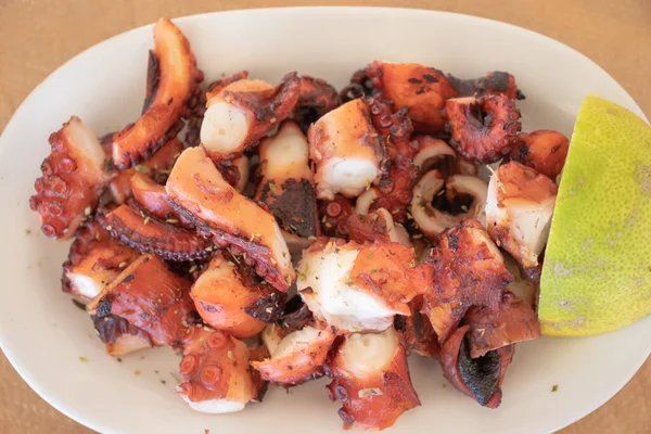 Cooked boiled and grilled octupus greek style on a white plate — Stock Photo, Image