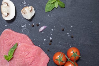 Çiğ malzemeler: kırmızı dilimlenmiş biftek, otlar, domatesler, sarımsak, tuz ve biber.