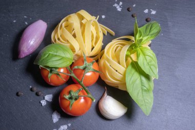 Domates ve sarımsaklı fesleğenli makarna için ham malzeme.